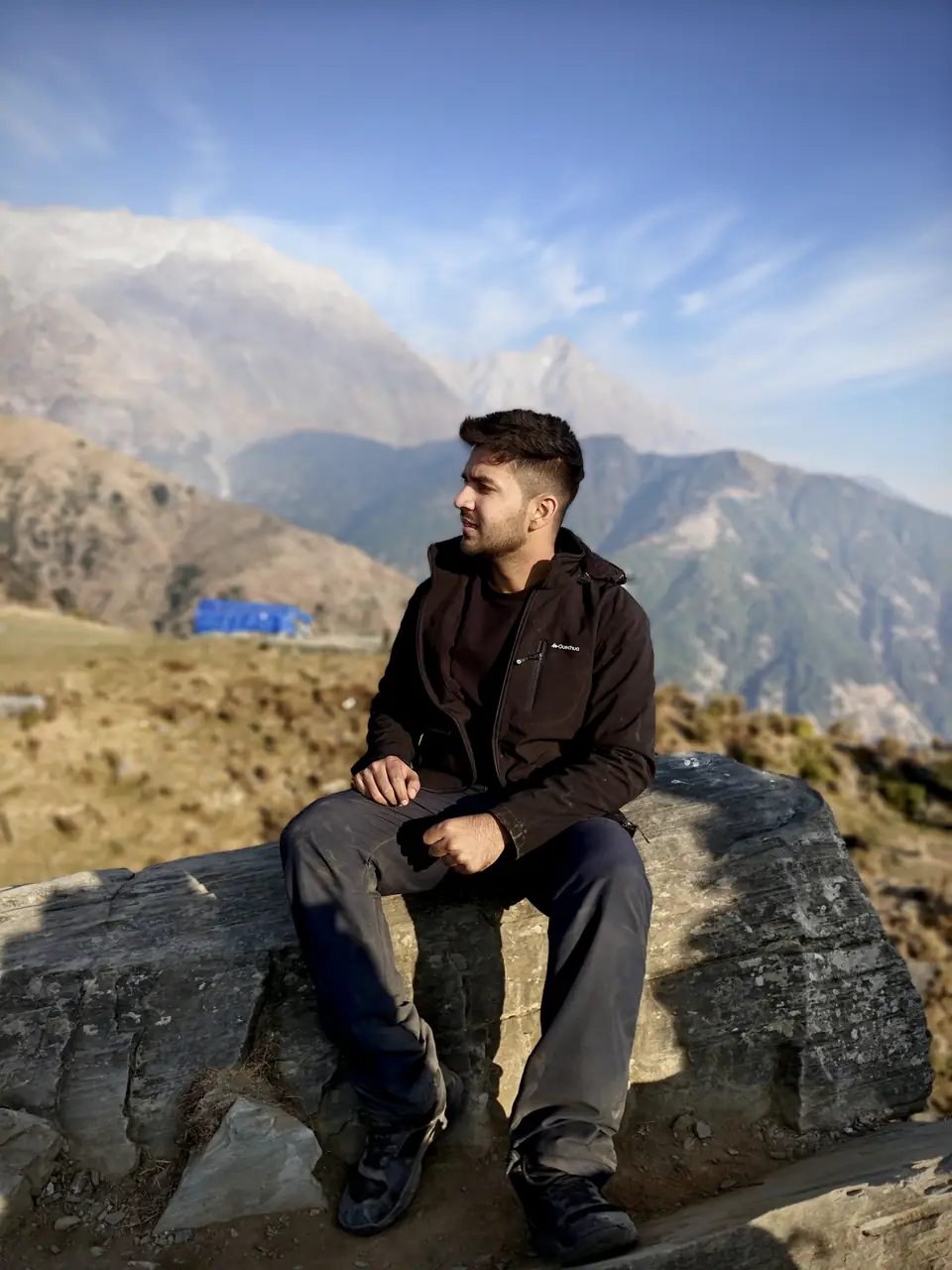 Pritish Bhatti in a black jacket, side profile on a Himalayan ridge in golden light